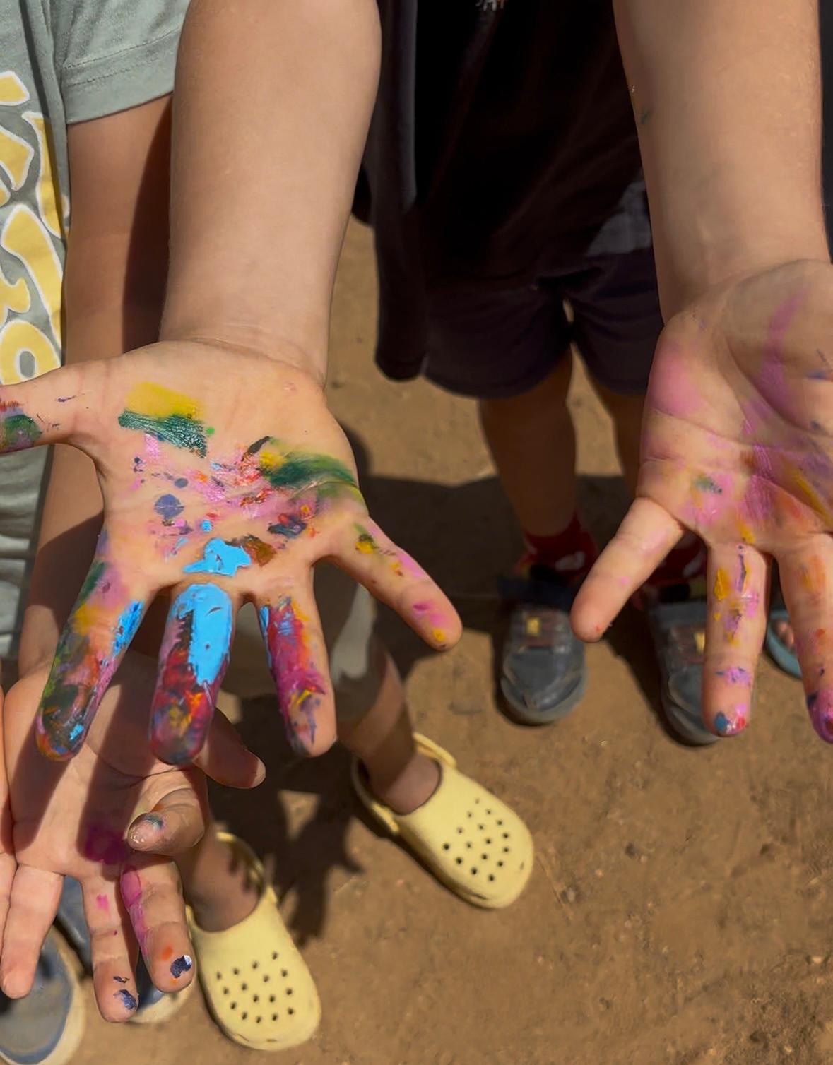 Mãos pintadas numa atividade criativa